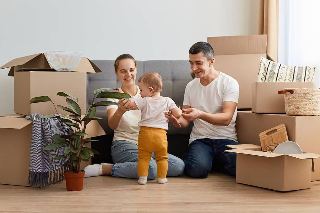 A young family unpacking moving boxes in their new home.